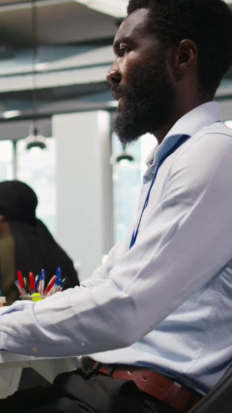 Vertical video Technician using mockup laptop next to office coworkers Stock Footage 312768885