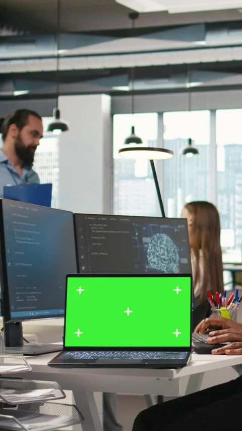 Vertical video Technician using mockup laptop next to office coworkers Stock Footage 312769286