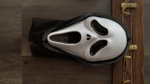 Vertical video a terrible scream mask hangs on a hook for things. A maniac in a Stock Footage 163777590