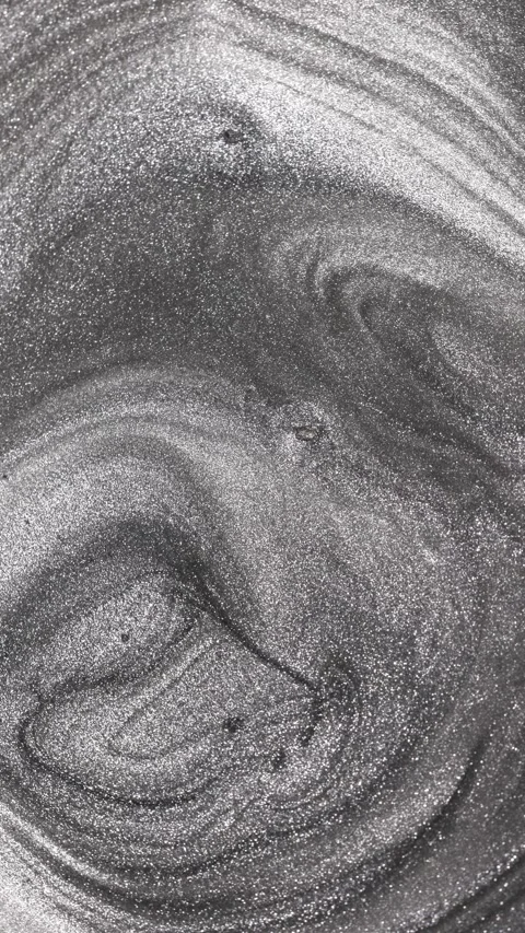 Vertical video of thick titanium paint swirling continuously into a deep Stock Footage 327604839