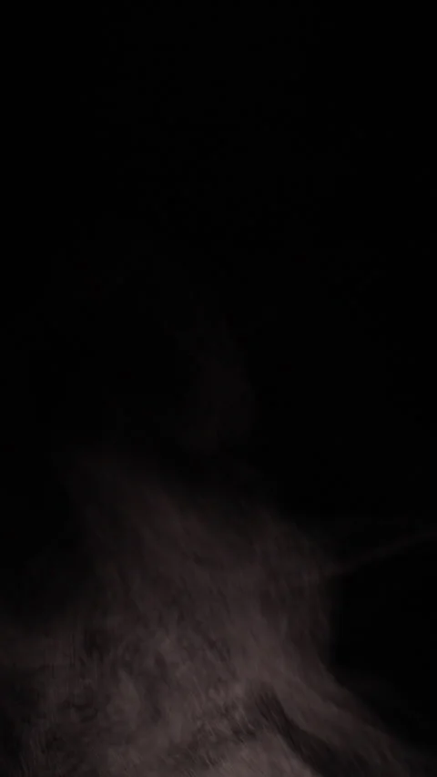 Vertical video. Thin Smoke Drifts Upward Against a Black Background, Creating a Stock Footage 341981884