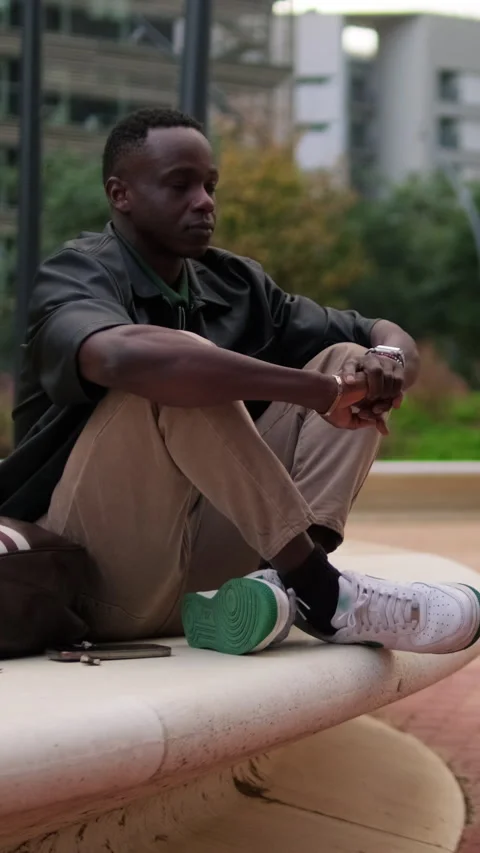 Vertical video, Thoughtful Young Man in a City Park. City landscape Stock Footage 328103432