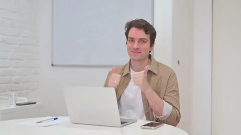 Vertical Video, Thumbs Up by Young Man while Working on Laptop 스톡 동영상 312914351