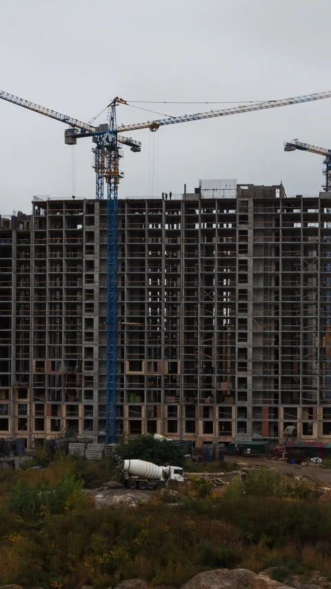 Vertical video time lapse of a highrise construction site with crane and clou Video stock 325508225