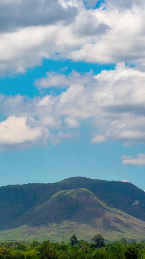 Vertical video time lapse of white clouds and blue sky with mountains. Stock Footage 310034550