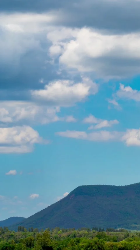 Vertical video time lapse of white clouds and blue sky with mountains. Stock Footage 310034551