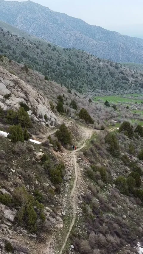 Vertical video: Tiny Hikers on Mountain Trail by Rushing River Aerial Video stock 332216891
