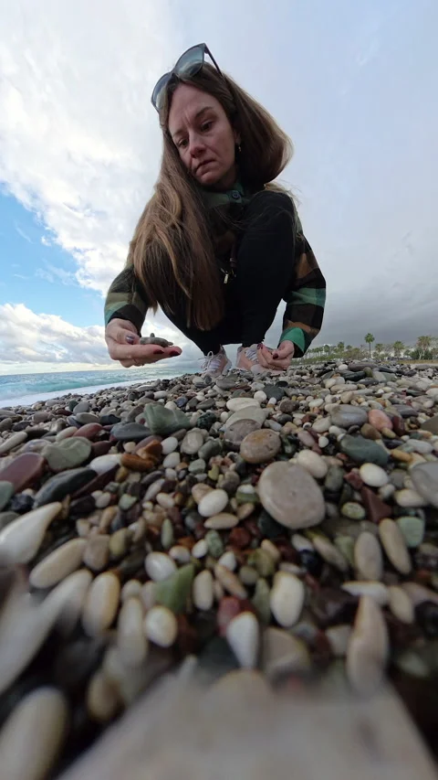 Vertical video. Tiny Planet perspective showing a woman collecting stones on a Stock Footage 293278198