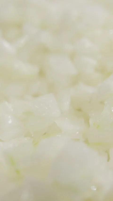 Vertical video. Tiny raw onion particles rest across metallic tray after Stock-Footage 323465258