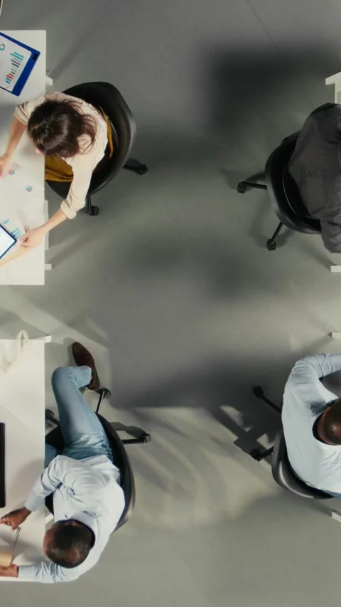 Vertical Video Top down view zoom out of corporate employees study business Stock Footage 319805903