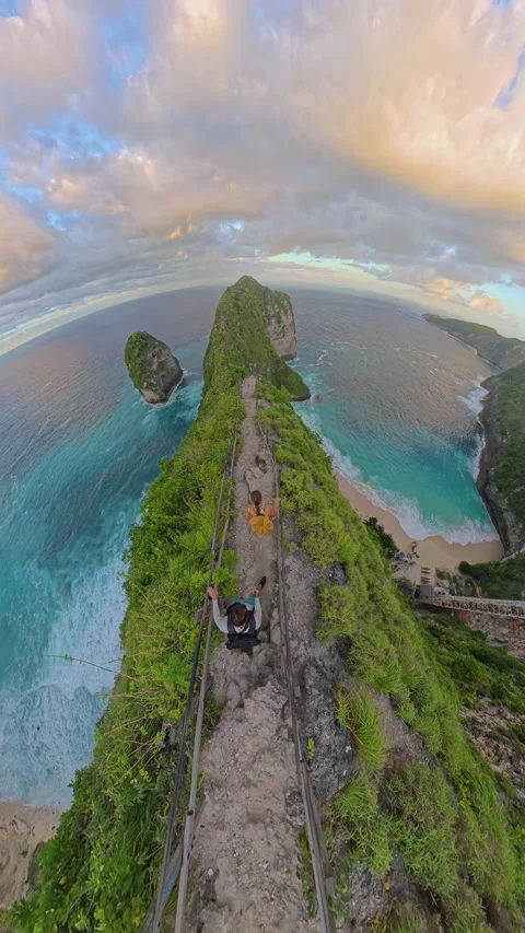 Vertical video. Top Down View of Two Tourists Descending Dangerous Cliff Path To Stock Footage 337099614