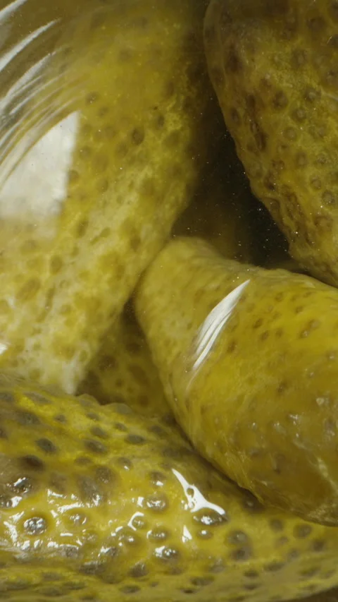 Vertical video. Top view of a jar with pickled cucumbers, camera inside. Dolly s Stock Footage 259963539