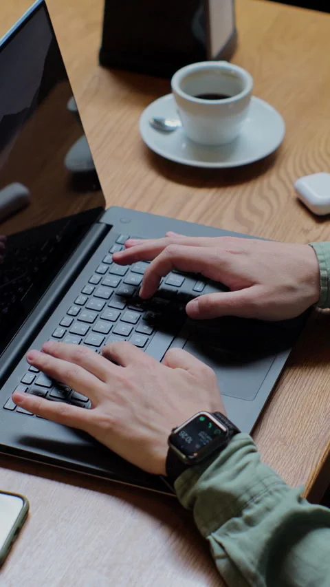 Vertical video. Top view of man in casual clothes is typing on a laptop Stock Footage 345235605