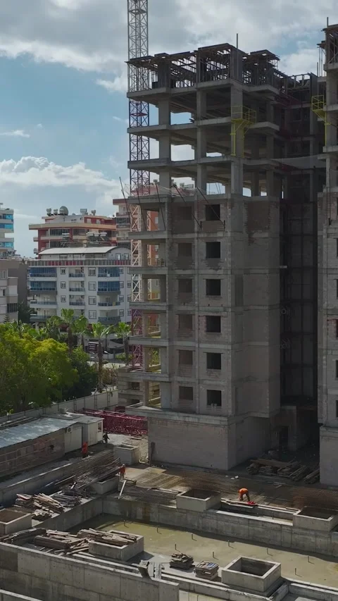 Vertical Video Tower Crane Positioned Above Concrete High Rise with Clear Blue Stock Footage 342447271