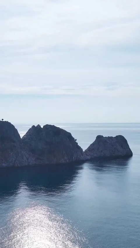 Vertical Video of a Towering Rock Formation in the Turquoise Waters of the Ocean Stock Footage 301339398