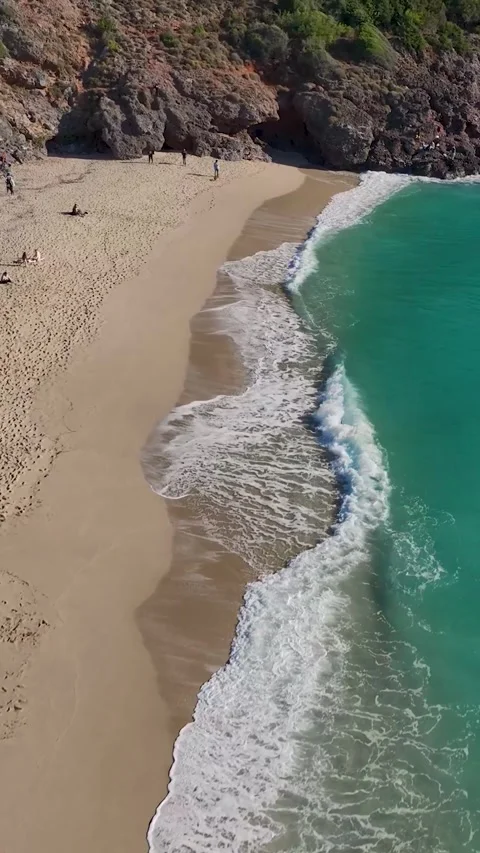Vertical Video: A tranquil Mediterranean beach featuring crystal-clear water Video stock 297680304