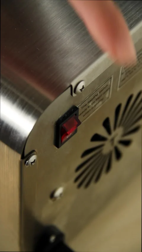 Vertical video. Turning on the heating element of the electric oil press. Stock Footage 168889471