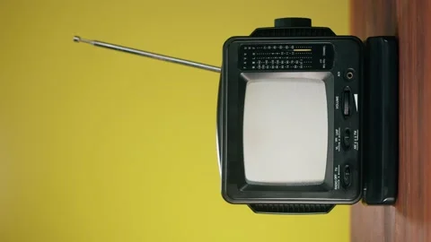 Vertical video of turning on small old television with grey interference screen Stock Footage 182005305