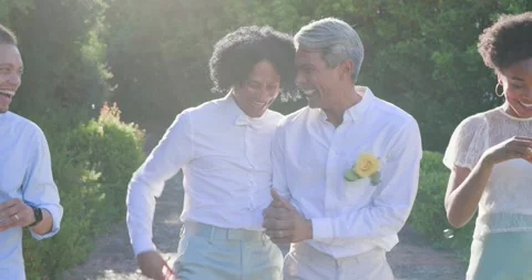 Vertical video: Two African American men walking on path while guests blowing Stock Footage 340457181