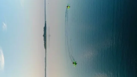 Vertical video. Two canoes with four rowers sail on Lake Video stock 237369713