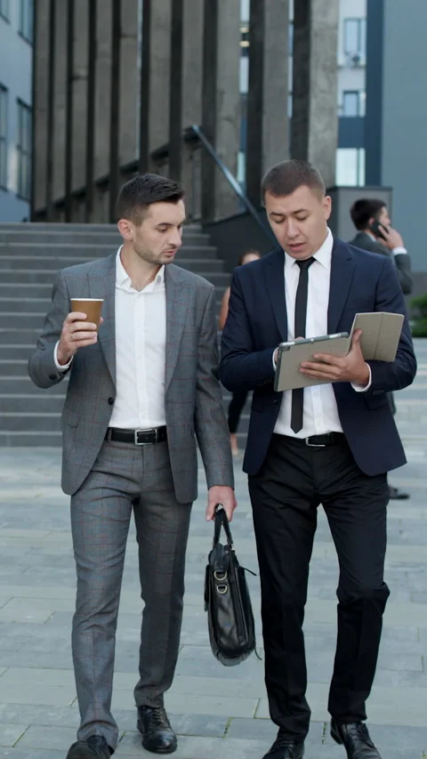 Vertical Video of Two Caucasian handsome businessmen in suits and ties holding Stock Footage 302562099