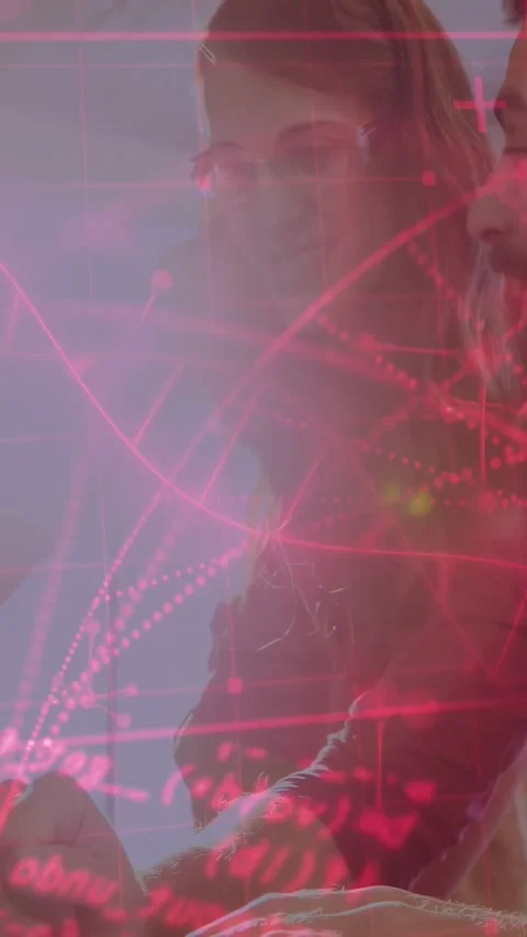 Vertical video: Two colleagues reading tech data on device, woman tapping, pink Stock Footage 334398081