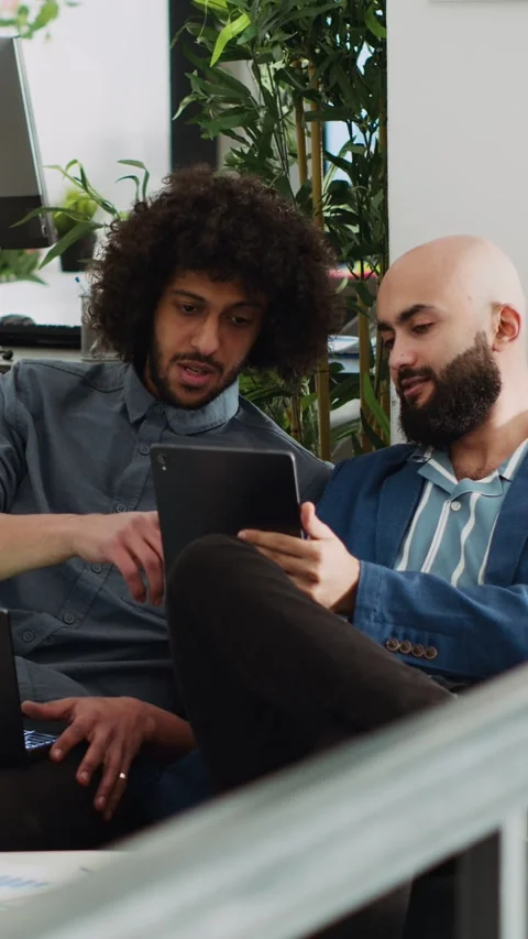 Vertical Video Two employees comparing notes in office Stock Footage 243729332