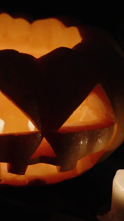 Vertical video. Two Halloween pumpkins with candles burning inside, one of them Stock Footage 247690207
