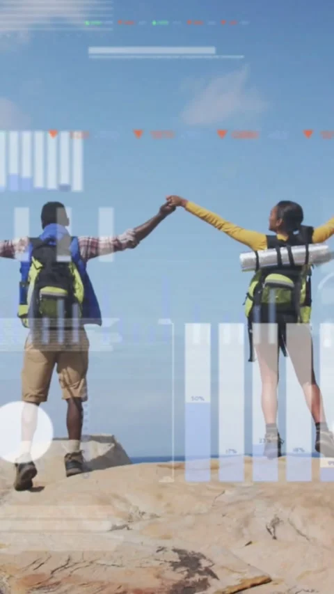 Vertical video: Two hikers clasping hands raising arms on coast, marking win, Stock Footage 331334402