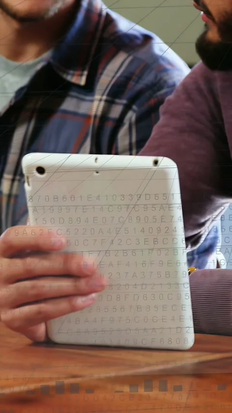 Vertical video: Two men leaning in, tilting tablet and showing IT charts, code Stock Footage 333954013