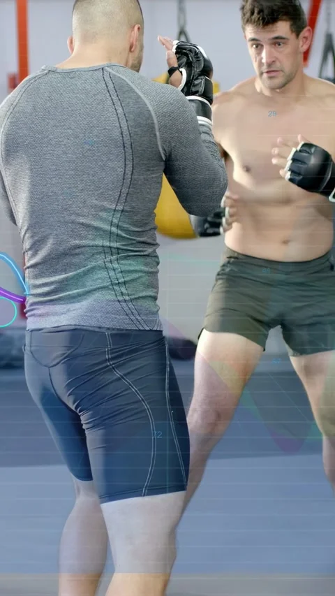 Vertical video: Two men sparring on mat, right man stepping, probing openings, Stock Footage 334297373