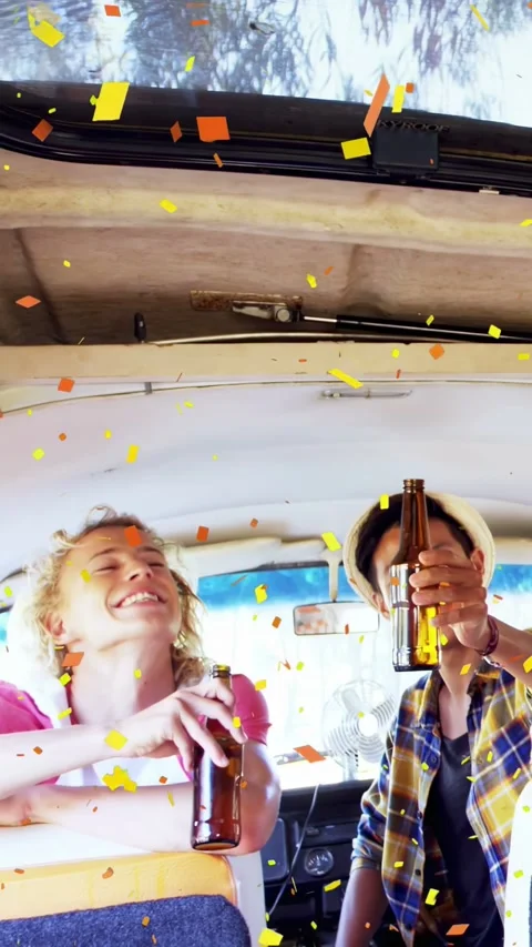 Vertical video: Two men toasting in van, blond man lifting beer bottle, confetti Stock Footage 340133456