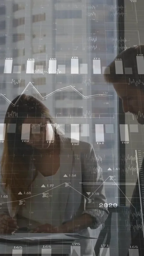Vertical video: Two pros at table tapping phone pulling finance charts over Stock Footage 334549857