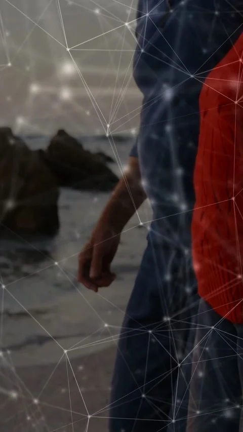 Vertical video: Two seniors walking shore as camera rises, activating node Video stock 333079797