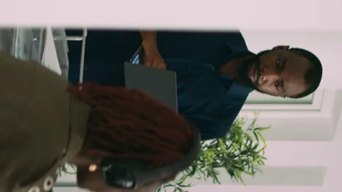 Vertical video: Two software coders analyzing source code looking for errors on Stock Footage 219702299