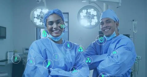 Vertical video: Two surgeons under surgical lights checking vitals holo icons Stock Photos