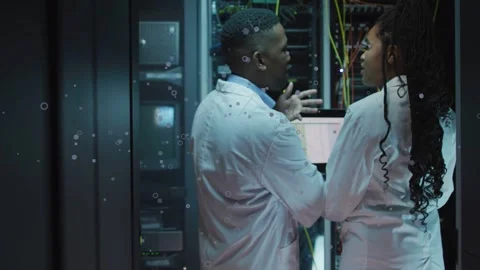 Vertical video: Two techs pointing with laptop, diagnosing cables in data center Stock Footage 332804702