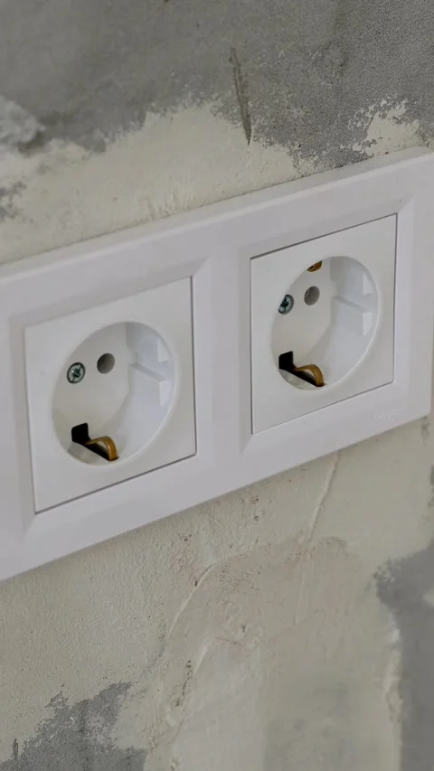Vertical video. A two white electrical outlets within mounted on a grey Video stock 294671333