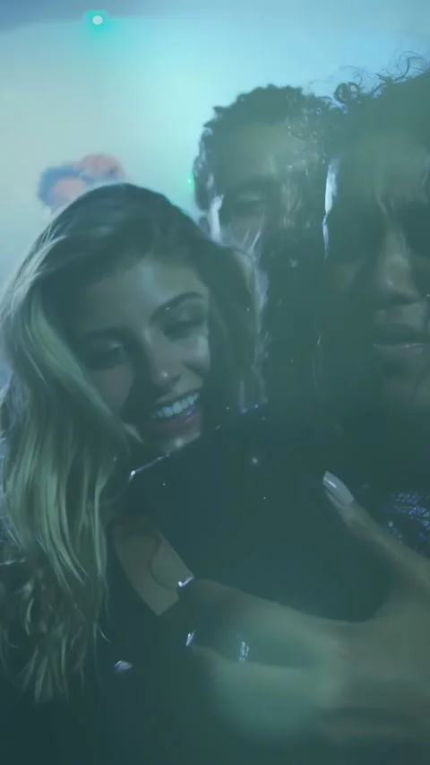 Vertical video: Two women lifting phone, checking screen, singing along with Stock Footage 334396145