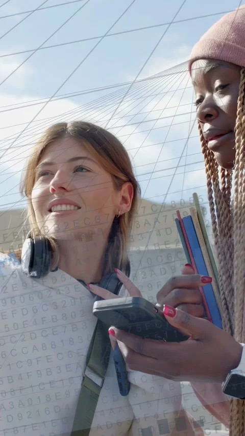 Vertical video: Two women moving phone, leaning in, sharing education notes, Stock Footage 333840307
