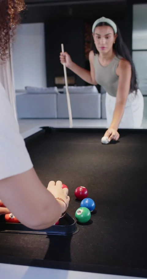 Vertical video: Two women prepping break at home pool table near racking balls Stock Footage 345040805