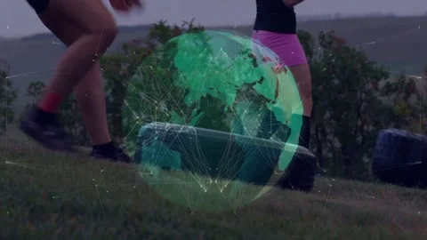 Vertical video: Two women stepping forward flipping tire for fitness drill globe Stock Footage 331333576