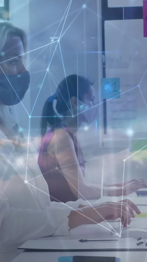 Vertical video: Two women typing, monitors sending data, tech overlay flowing Stock Footage 332506901