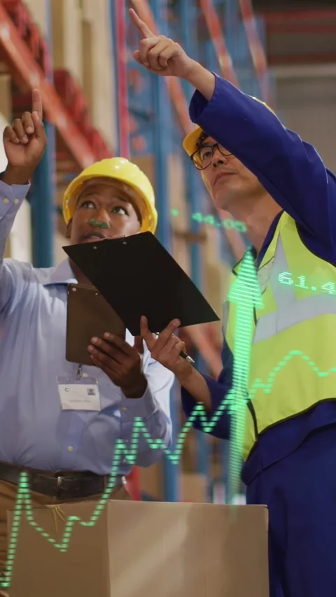 Vertical video: Two workers checking clip pointing causing green graph to shelf Stock Footage 334377473