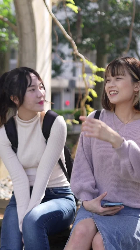 Vertical video of two young Taiwanese female college students sitting Stock Footage 266386926
