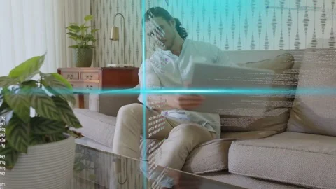 Vertical video: Typing man in light shirt in living room, overlay emerging Stock Footage 333004958