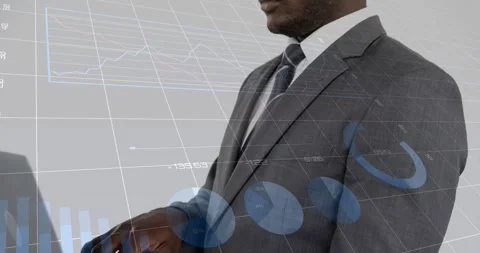 Vertical video: Typing man using laptop in grey suit, tie during pullback at Stock Footage 331176266
