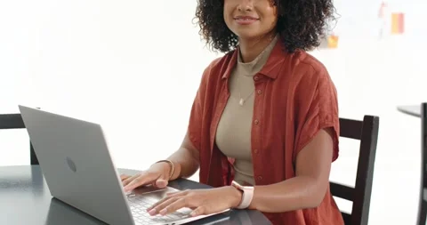 Vertical video: Typing woman in rust top smiling as camera pulling back at Vídeos de archivo 340974465