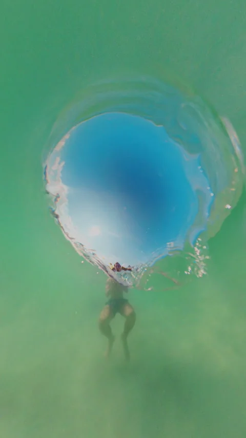 Vertical video. Underwater View Looking Up At Surface Opening With Person Below, Stock Footage 333280281