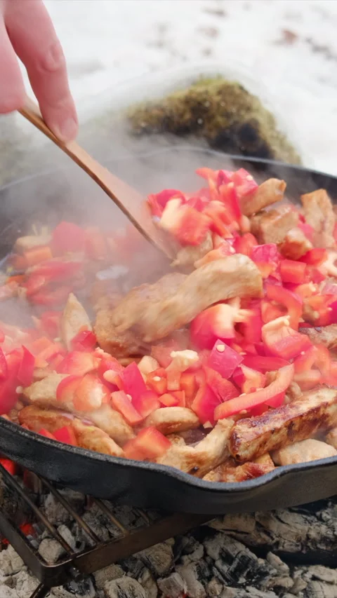 Vertical video of unknown young man fries vegetables with meat in pan Stock Footage 308708562